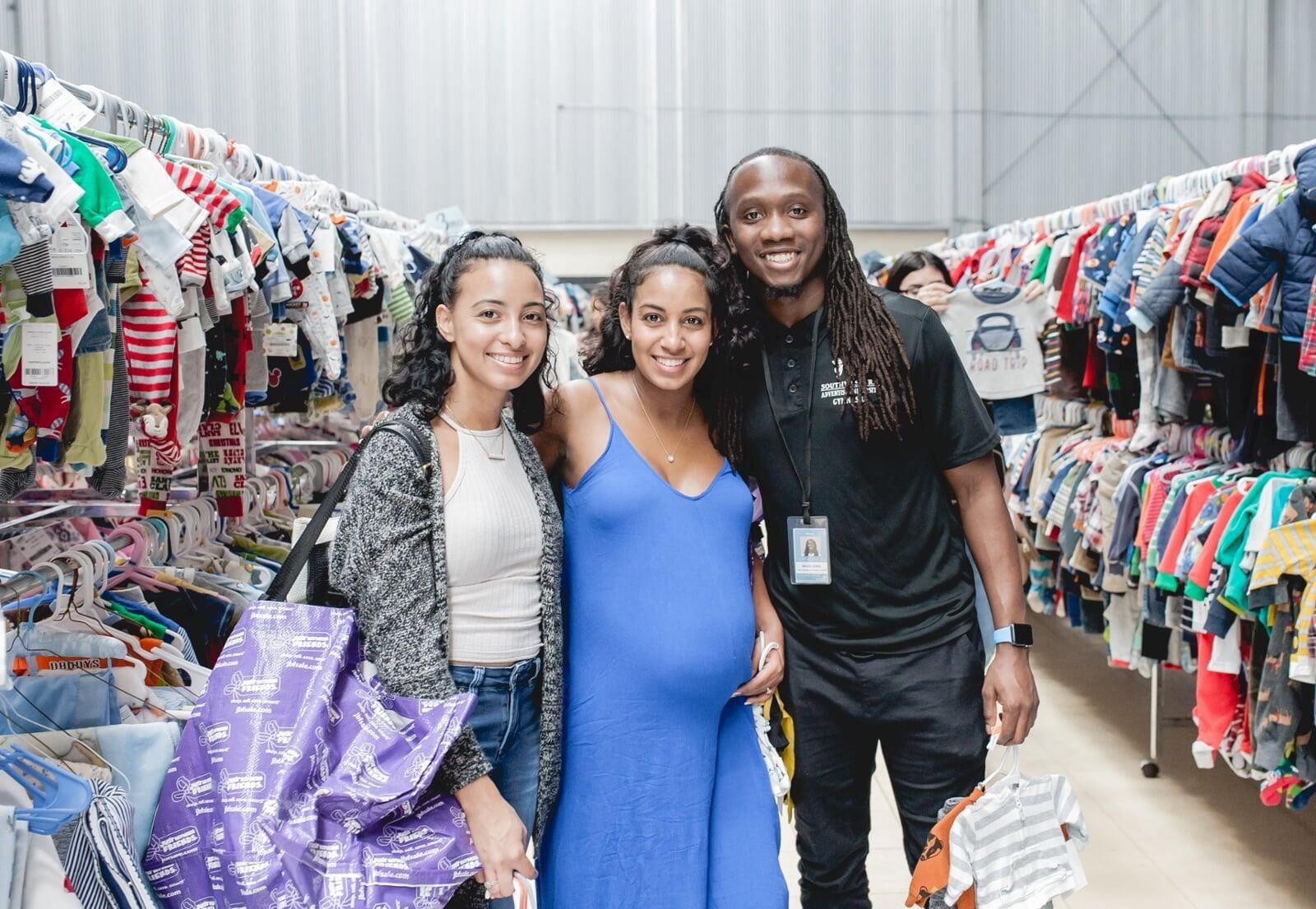 Two friends shop together—one mom wears her baby girl—as they find great deals at the JBF sale.